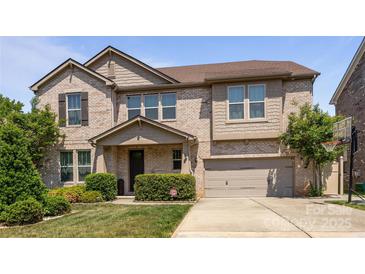 Charming two-story brick home featuring a two-car garage and professionally landscaped front yard at 8614 Goodman Park Ct, Charlotte, NC 28277