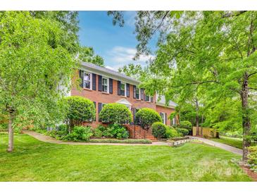 Charming brick home with lush landscaping, inviting stairs, and classic architectural details at 1023 Evian Ln, Matthews, NC 28105