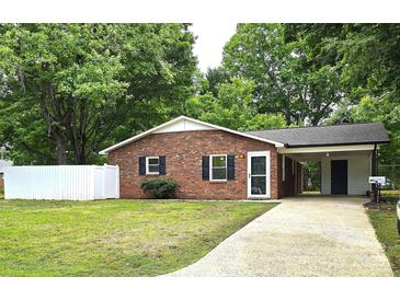 Charming single-story brick home featuring a well-manicured lawn and a convenient carport at 11 N 10Th Ave, Maiden, NC 28650