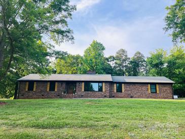 Charming one-story brick home with symmetrical design and a well-maintained lawn, surrounded by mature trees at 1207 Carlson Dr # 10, Monroe, NC 28110
