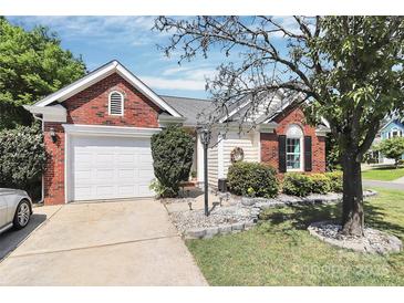 Charming brick and siding home featuring a well-manicured front yard and attached garage at 13612 Bolingbrook Ln, Charlotte, NC 28273
