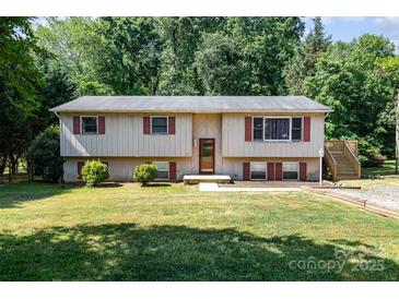 Inviting home featuring a well-manicured lawn, front entrance, and stairs to the side entry at 154 Seven Oaks Ln, Statesville, NC 28677