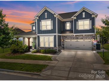 Attractive two-story home features a two-car garage and a well-manicured lawn under a colorful sunset at 17513 Julees Walk Ln, Davidson, NC 28036