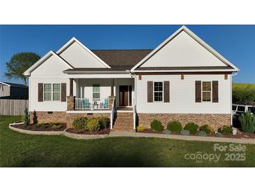 Charming home with white siding, brown shutters, brick foundation and inviting front porch at 179 Foy Ln, Statesville, NC 28625
