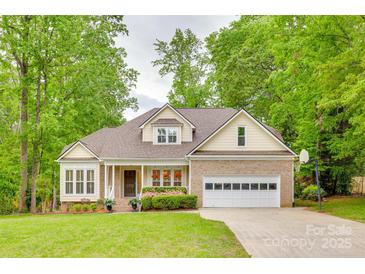 Charming home with a two-car garage, covered front porch, well-manicured lawn, and lush landscaping at 2345 Sparrow Dr, Rock Hill, SC 29732