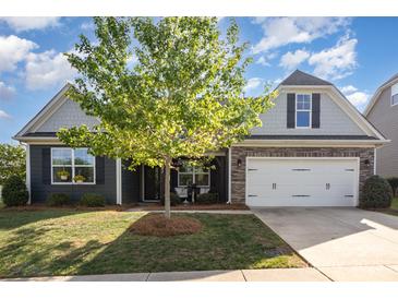 Charming home featuring gray siding, stone accents, manicured lawn, and a two-car garage at 3267 Lock Erne Ave, Kannapolis, NC 28081