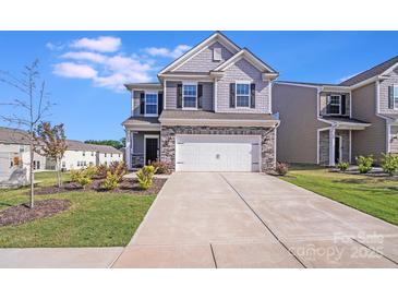 Charming two-story home with stone accents, well-maintained lawn, and a two-car garage at 356 Runner Stone Ln, Fort Mill, SC 29715