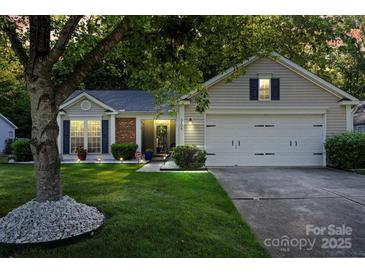 Inviting home featuring a manicured lawn, mature tree, and a two-car garage at 3604 Braefield Dr, Indian Trail, NC 28079