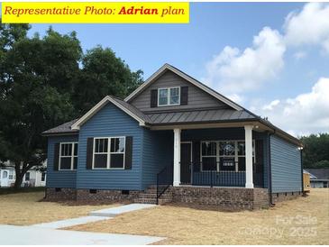 Charming single-story home with blue siding, covered porch, and manicured lawn at 408 N Peterson St, Stanley, NC 28164