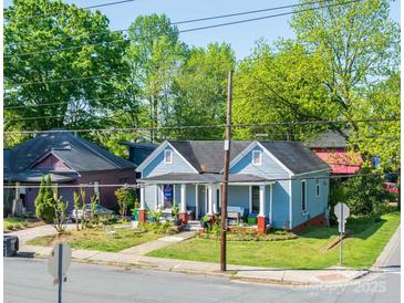 Charming blue home with inviting front porch and well-maintained lawn and shrubs at 600 E 35Th St, Charlotte, NC 28205
