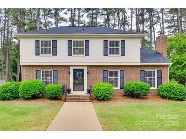 Charming two-story brick home with manicured landscaping, black shutters, and inviting entryway at 8525 Castlekeep Rd # 26, Charlotte, NC 28226