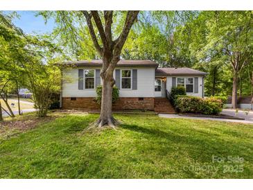 Charming single-story home with a well-maintained lawn and mature tree in a tranquil, wooded setting at 9640 Heartwood Ln, Mint Hill, NC 28227