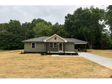 Charming single-story home with olive green siding, covered carport, and newly seeded front yard at 1428 E Main St, Cherryville, NC 28021