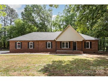 Charming single-story brick home featuring black shutters, a front lawn, and mature trees providing ample shade at 1513 White Ridge Dr, Rock Hill, SC 29732