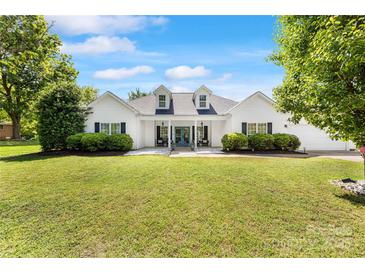 Charming white home with dormers, a covered porch, and a lush green lawn at 1728 Privette Rd, Matthews, NC 28105