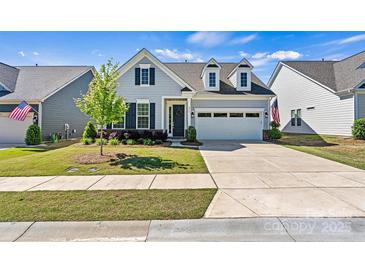 Charming home with a two-car garage, neat landscaping and an American flag displayed in the front yard at 213 Warbler Dr, Monroe, NC 28110