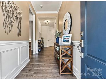 Inviting entryway features wood-look flooring, stylish decor, and a convenient display table at 213 Warbler Dr, Wesley Chapel, NC 28110