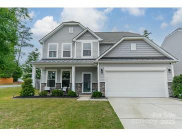 Charming two-story home featuring stone accents, a two-car garage, and a well-manicured lawn at 3205 Berry Creek Rd, Charlotte, NC 28214