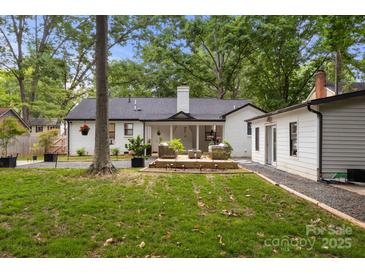 Charming backyard featuring a deck, lush lawn and plenty of trees offering shade at 3538 Denson Pl, Charlotte, NC 28215