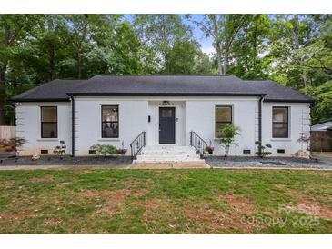 Charming single-story home featuring a painted brick facade, dark trim, and well-maintained landscaping at 3538 Denson Pl, Charlotte, NC 28215