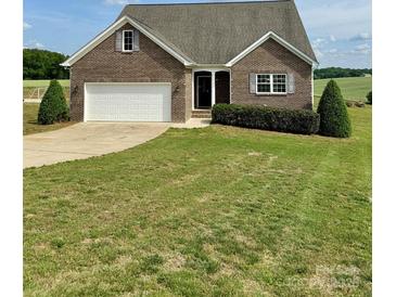 Charming brick home featuring an attached two-car garage and a well-maintained, expansive lawn at 4048 Avis Way, Monroe, NC 28110
