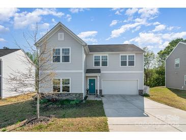 Charming two-story home features a teal door, stone accents, and a well-maintained front yard on a sunny day at 518 Dutch White Dr, Clover, SC 29710