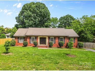 Charming single-story brick home with well-manicured lawn, trimmed shrubs and double front doors at 6301 Cherrycrest Ln, Charlotte, NC 28217