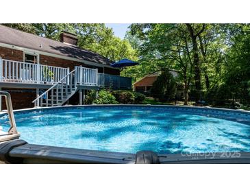 Relaxing above-ground pool with inviting blue water, deck, and peaceful backyard setting at 701 5Th Ne Ave, Conover, NC 28613