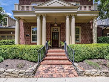 Stately brick home featuring a grand front entrance with brick steps, and large support columns at 7011 Conservatory Ln, Charlotte, NC 28270