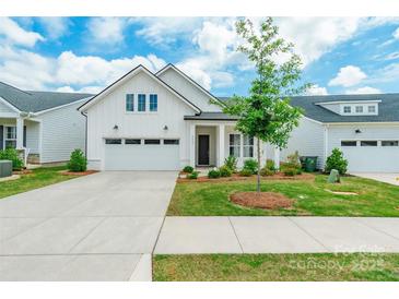 Charming single-story home featuring a white exterior, well-manicured lawn, and attached two car garage at 8008 Brookbank Dr, Charlotte, NC 28269