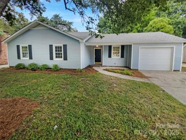 Charming single-story home with light blue siding, black shutters, and a well-maintained front yard at 10701 Copper Field Dr, Pineville, NC 28134
