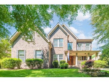Charming two-story brick home with well-maintained landscaping and inviting front porch at 11224 Warfield Ave, Huntersville, NC 28078