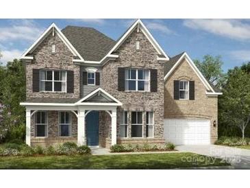 Beautiful two-story stone and brick home featuring a symmetrical design and manicured landscaping at 11913 Casabella Dr, Huntersville, NC 28078
