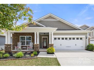 Charming single-Gathering home featuring a well-manicured lawn and stone accents on the front exterior at 1221 Brookcrest Ln, Fort Mill, SC 29708
