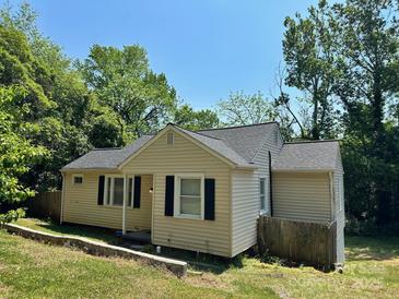Charming single-story home with neutral siding, dark shutters and roof, and a partially wooded lot at 2434 Columbus Cir, Charlotte, NC 28208