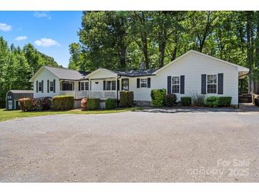 Charming single-story home with a covered porch, black shutters, mature trees and an expansive paved driveway at 370 Shiloh Rd, Statesville, NC 28677