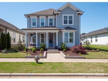 Charming two-story home featuring a welcoming front porch with a swing and a well-manicured landscaped yard at 371 Luray Way, Rock Hill, SC 29730