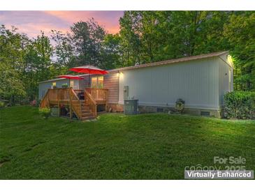 Charming home featuring a lovely wooden deck perfect for outdoor relaxation and entertaining under bright red umbrellas at 743 Dream Ln, Salisbury, NC 28146