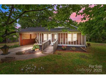 Charming brick home featuring a covered front porch, landscaped yard and walkway leading to the entrance at 1233 E Cannon Ave, Albemarle, NC 28001