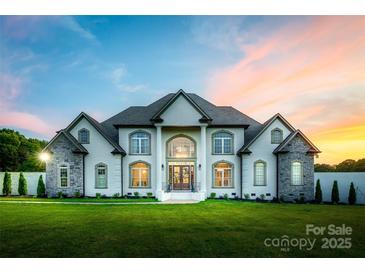 Stunning white brick home featuring a manicured green lawn and architectural details and a beautiful dusk sky at 1351 Highway 324 None, Rock Hill, SC 29730