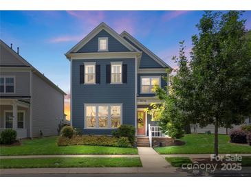 Charming two-story home featuring well-manicured lawn, lush greenery, and inviting front porch at 13714 Jacks Ln, Pineville, NC 28134