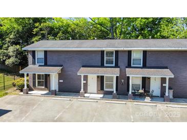 Brick two-story townhome with covered porch, black shutters, and ample parking at 1512 Seigle Ave # 2, Charlotte, NC 28205