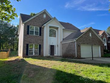 Charming two-story home with brick and vinyl siding, an attached two car garage, and a well-manicured lawn at 16017 Woodcote Dr, Huntersville, NC 28078
