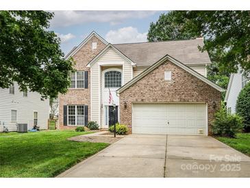 Charming two-story brick home featuring an attached two-car garage and well-maintained landscaping at 16017 Woodcote Dr, Huntersville, NC 28078
