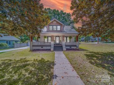 Charming two-story home features a welcoming front porch and meticulously landscaped front yard at 232 W Wilson Ave, Mooresville, NC 28115