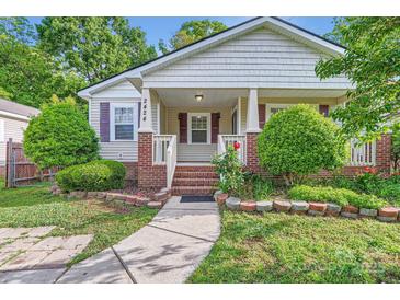 Charming single-story home with a covered front porch and well-manicured landscaping at 2424 Pitts Dr, Charlotte, NC 28216