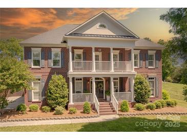 Stunning brick home with a double porch, columns, and beautifully landscaped front yard at 4117 Wallbrook Dr, Matthews, NC 28105