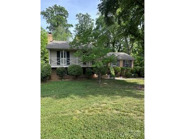 Charming home with a covered front porch and manicured lawn surrounded by mature trees at 5938 Sharon Rd, Charlotte, NC 28210