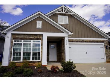 Inviting home featuring stone accents, a white garage door, and a well-manicured front yard, offering appealing curb appeal at 6642 Star Dr, Sherrills Ford, NC 28673