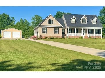 Charming home boasts a two-car garage, well-maintained lawn, and classic architectural details under a clear blue sky at 945 Songbird St, Lancaster, SC 29720